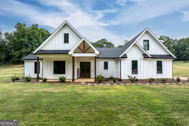 modern farmhouse featuring covered porch and a front lawn