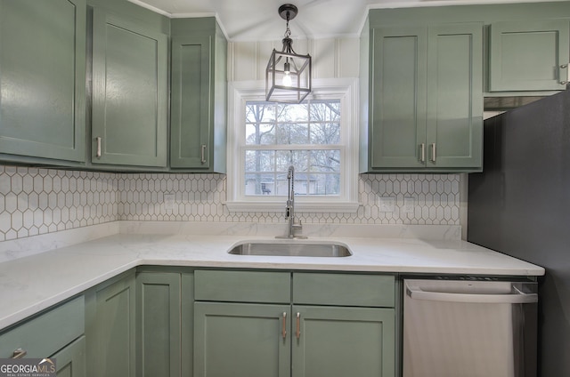 kitchen featuring tasteful backsplash, stainless steel appliances, sink, decorative light fixtures, and green cabinets