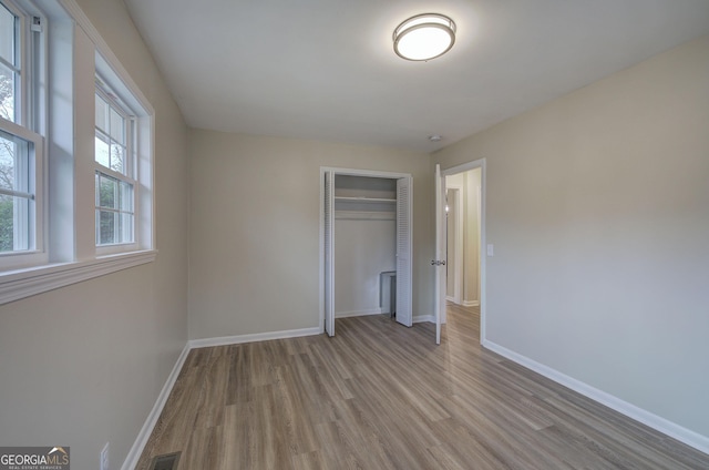 unfurnished bedroom with light hardwood / wood-style flooring and a closet