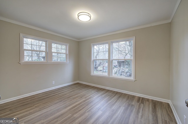 unfurnished room featuring wood-type flooring and crown molding