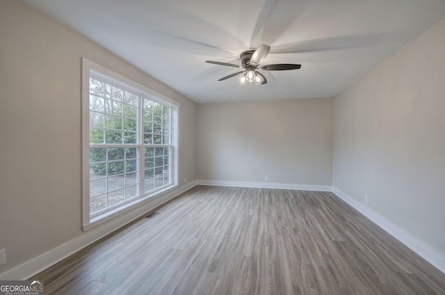 empty room with hardwood / wood-style floors and ceiling fan