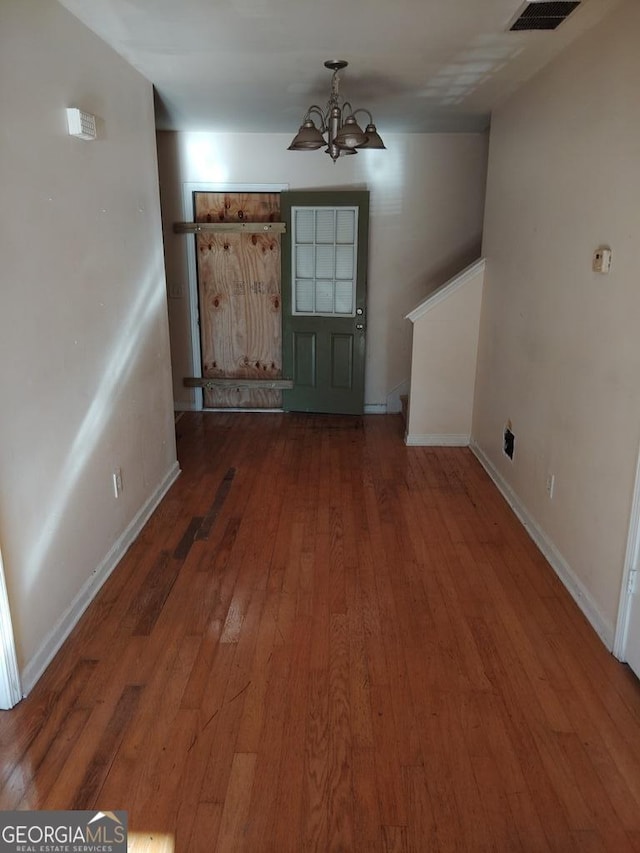 interior space with a chandelier and dark hardwood / wood-style floors