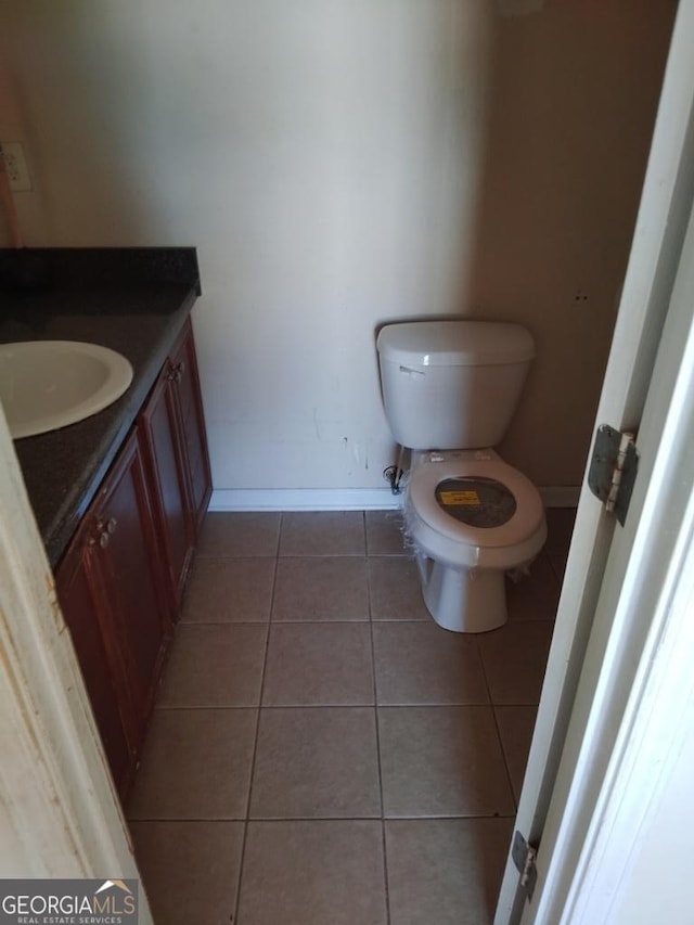 bathroom with tile patterned flooring, vanity, and toilet