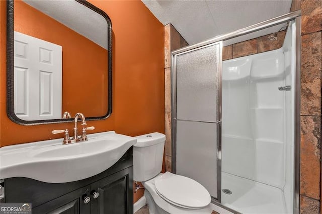 bathroom featuring vanity, an enclosed shower, a textured ceiling, and toilet