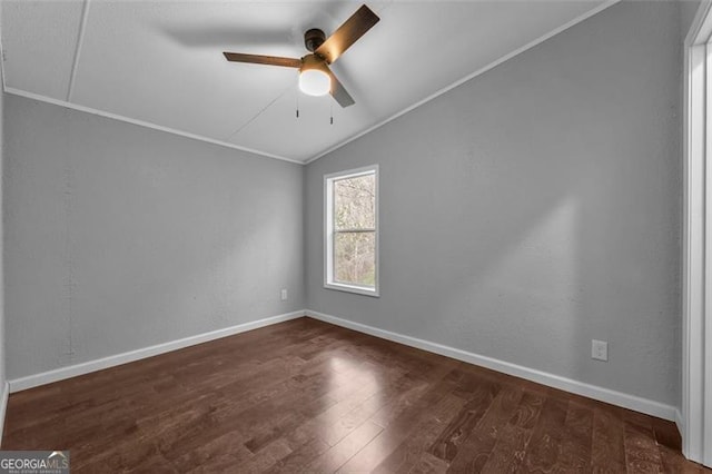 spare room featuring ceiling fan, dark wood-type flooring, lofted ceiling, and ornamental molding