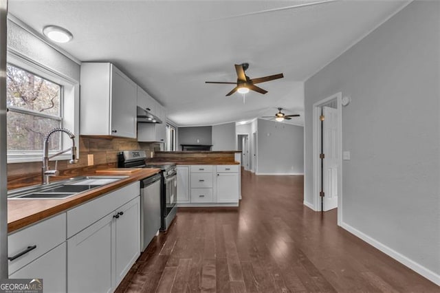 kitchen with dark hardwood / wood-style flooring, stainless steel appliances, sink, white cabinets, and lofted ceiling