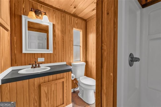 bathroom with vanity, tile patterned floors, wooden walls, toilet, and wood ceiling