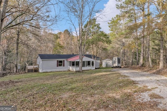 single story home with a deck and a front lawn