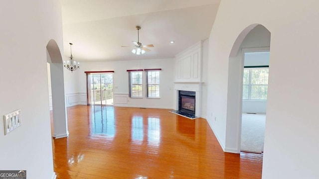 unfurnished living room with a premium fireplace, light hardwood / wood-style floors, and ceiling fan with notable chandelier