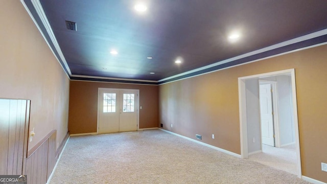 carpeted spare room featuring crown molding