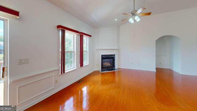 unfurnished living room with a high end fireplace, hardwood / wood-style flooring, and ceiling fan