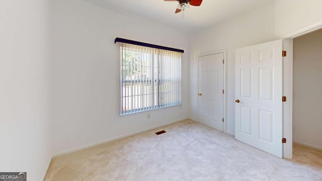 unfurnished bedroom featuring ceiling fan and light colored carpet