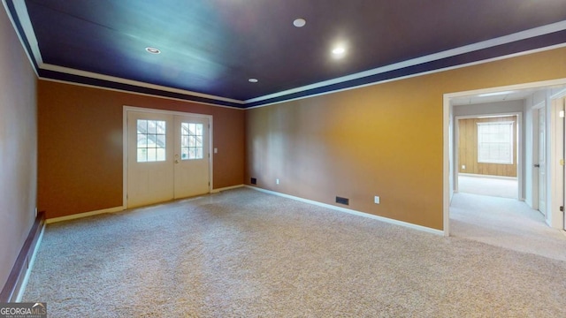 empty room with ornamental molding, light carpet, and french doors