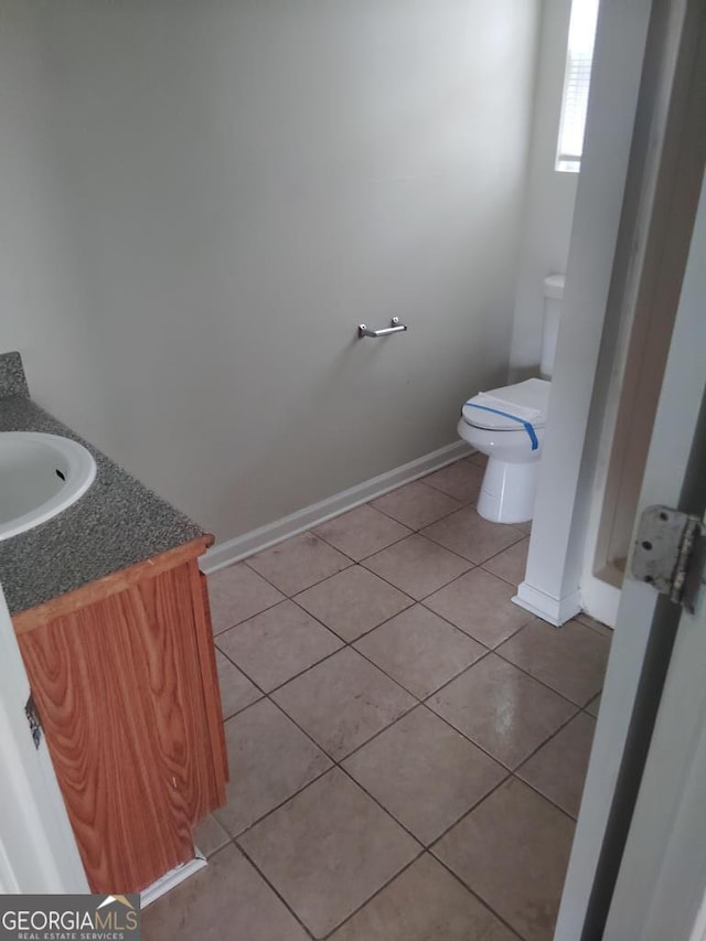 bathroom featuring toilet, vanity, and tile patterned floors