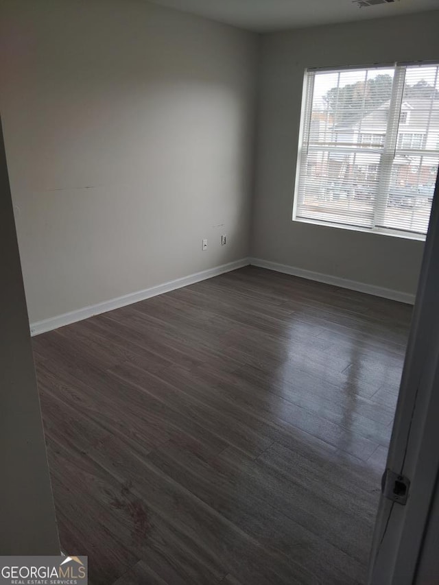 unfurnished room featuring dark wood-type flooring