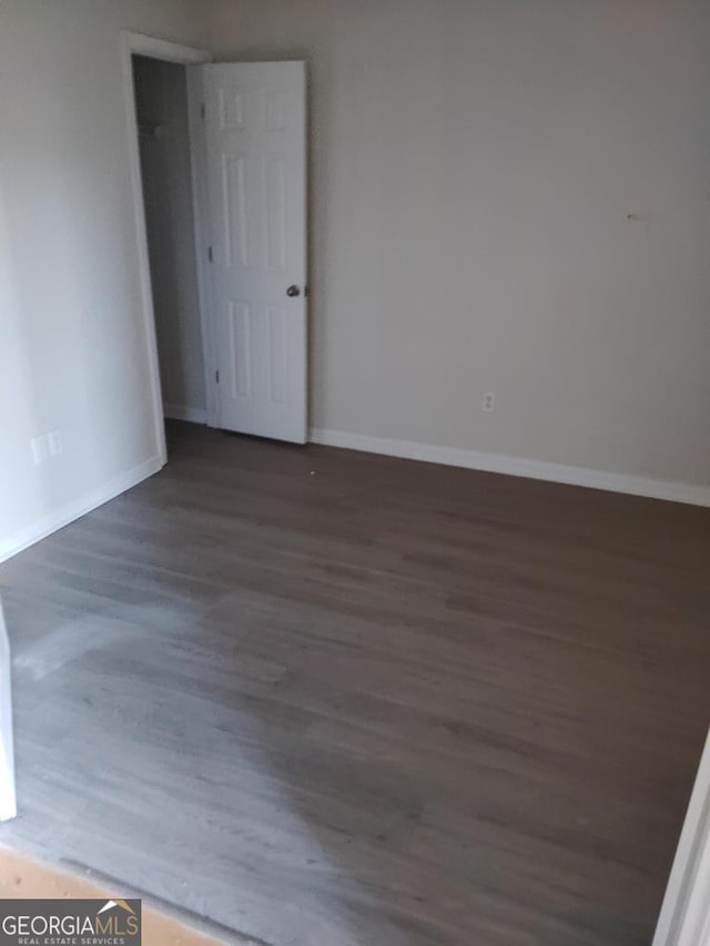 empty room with dark wood-type flooring