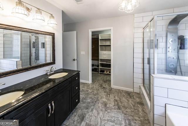 bathroom featuring a shower with shower door and vanity