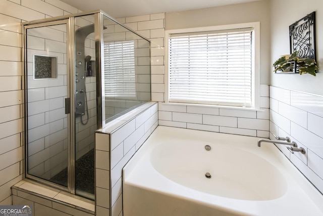 bathroom featuring independent shower and bath and a wealth of natural light