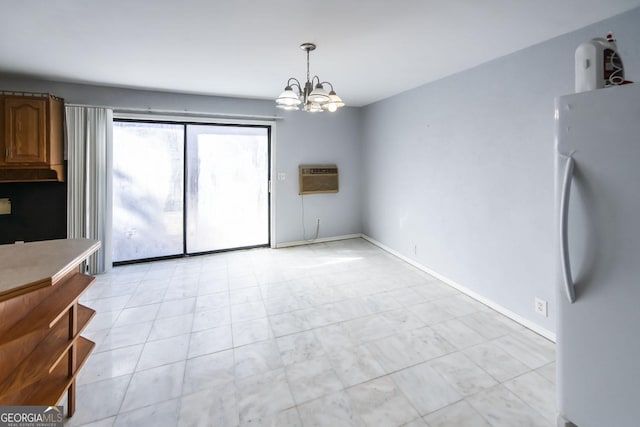 unfurnished dining area featuring a chandelier and a wall unit AC