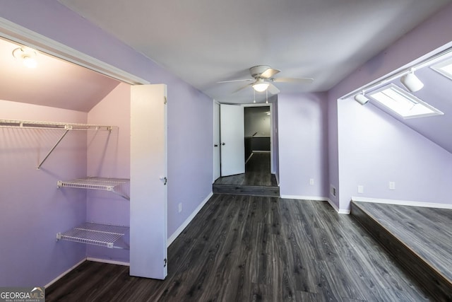 additional living space with ceiling fan, dark hardwood / wood-style floors, and lofted ceiling with skylight