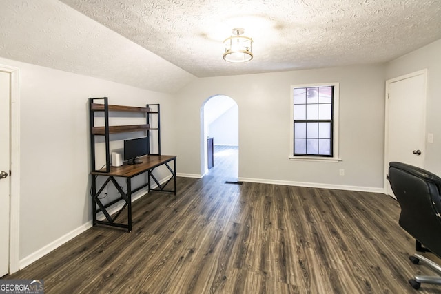 home office featuring vaulted ceiling, dark wood-type flooring, and a textured ceiling