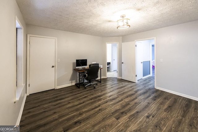 home office with a textured ceiling and dark hardwood / wood-style flooring