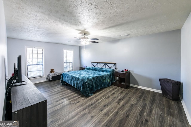 bedroom with ceiling fan, dark wood-type flooring, and a textured ceiling