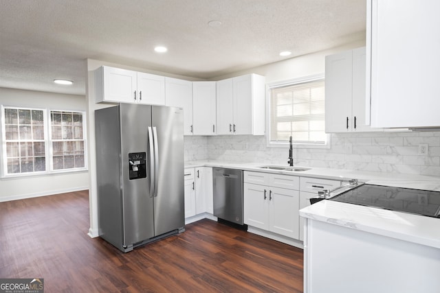 kitchen with white cabinets, appliances with stainless steel finishes, dark hardwood / wood-style flooring, and sink