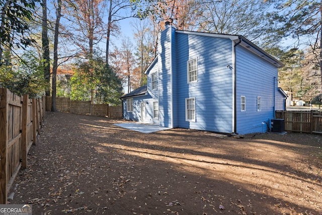 rear view of house featuring a patio and central AC