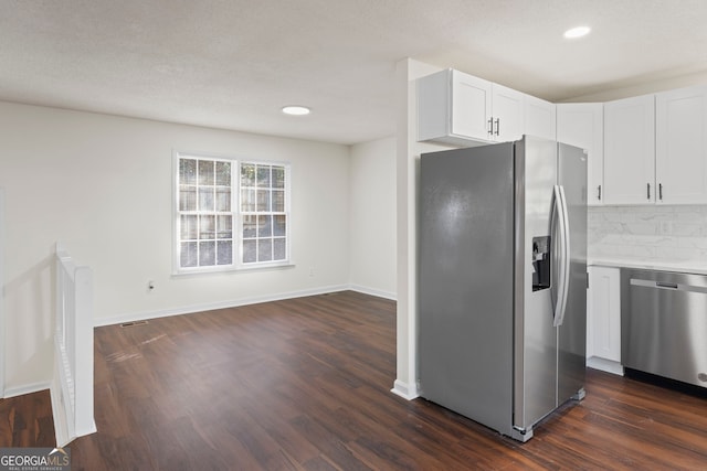 kitchen featuring tasteful backsplash, dark hardwood / wood-style floors, a textured ceiling, white cabinets, and appliances with stainless steel finishes