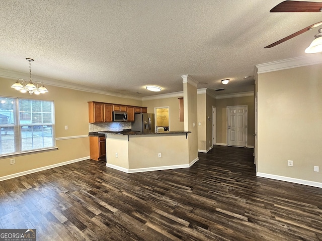 kitchen with crown molding, dark hardwood / wood-style flooring, decorative light fixtures, and appliances with stainless steel finishes