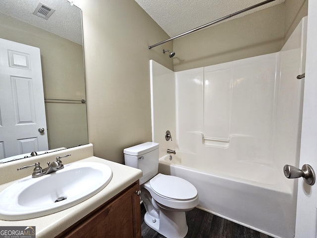 full bathroom with vanity, toilet, a textured ceiling, shower / bathtub combination, and wood-type flooring