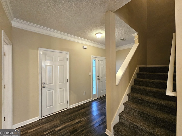 entrance foyer featuring a textured ceiling, dark hardwood / wood-style flooring, and ornamental molding