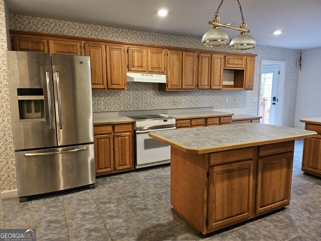 kitchen featuring ceiling fan, sink, white range, decorative light fixtures, and a kitchen island