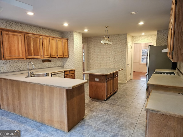 kitchen featuring kitchen peninsula, sink, light tile patterned floors, a kitchen island, and hanging light fixtures