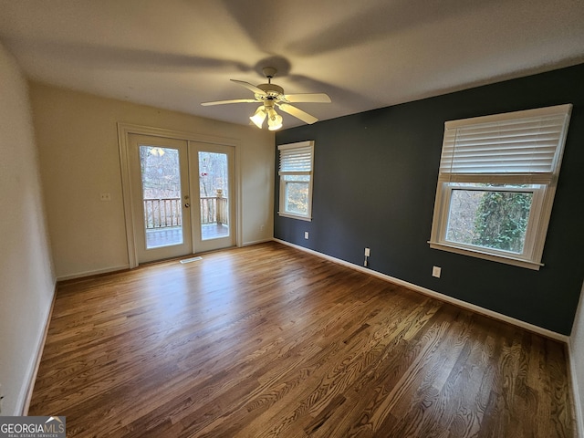 spare room featuring hardwood / wood-style flooring, ceiling fan, and french doors