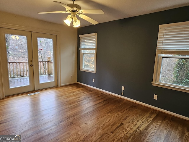 unfurnished room featuring french doors, hardwood / wood-style flooring, and a healthy amount of sunlight