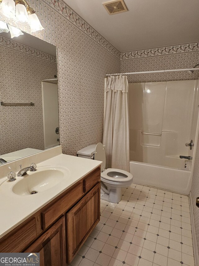 full bathroom with shower / bath combination with curtain, toilet, and vanity