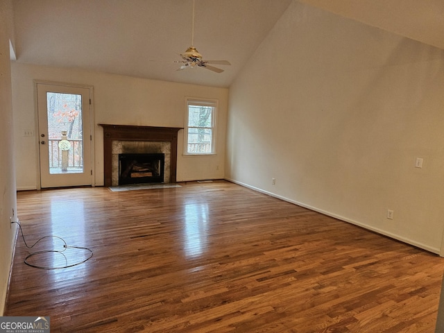 unfurnished living room featuring ceiling fan, wood-type flooring, a fireplace, and vaulted ceiling