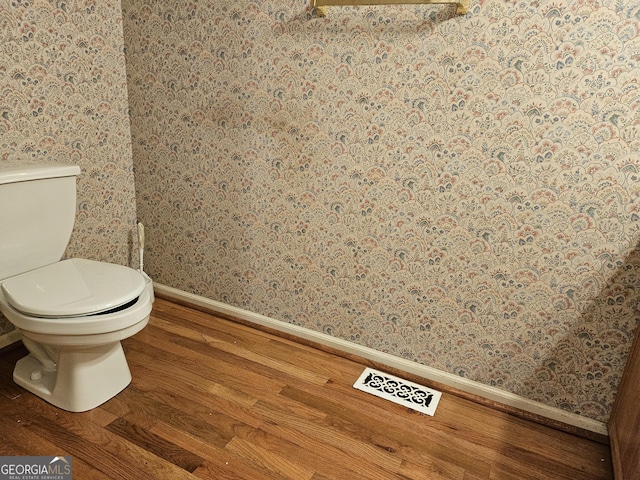 bathroom featuring hardwood / wood-style floors and toilet