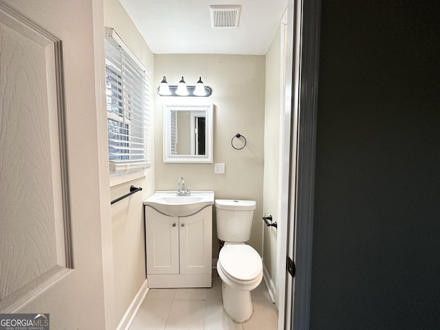 bathroom with tile patterned flooring, vanity, and toilet