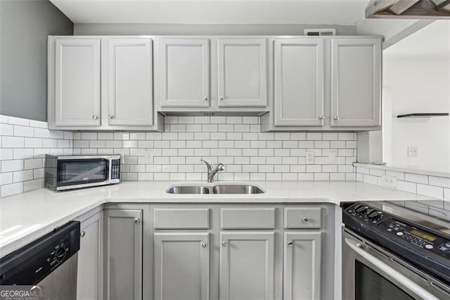 kitchen featuring decorative backsplash, white cabinetry, sink, and appliances with stainless steel finishes