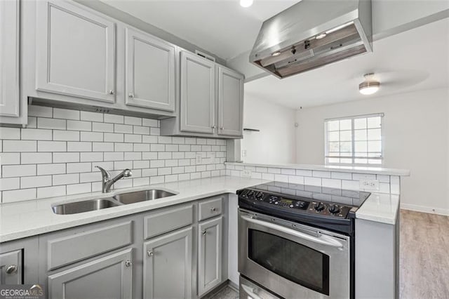 kitchen with backsplash, light hardwood / wood-style floors, stainless steel electric range oven, and sink