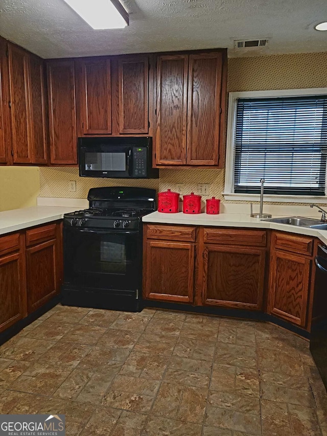 kitchen featuring black appliances, backsplash, and a textured ceiling