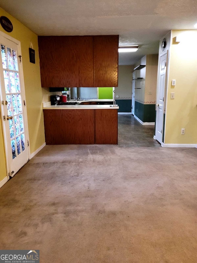 kitchen featuring kitchen peninsula and dark carpet