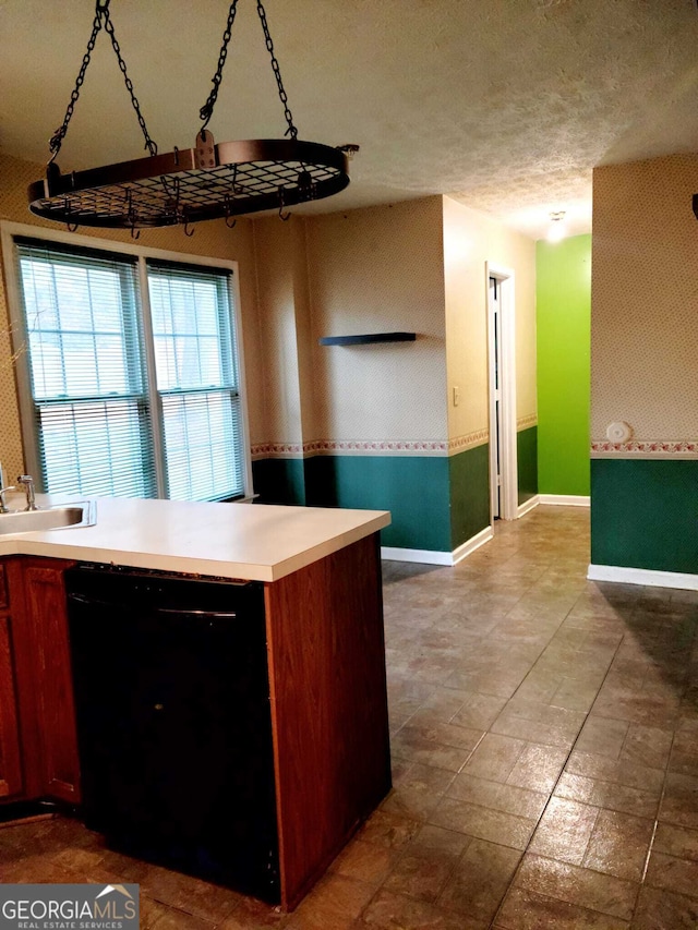 kitchen featuring dishwasher, a textured ceiling, and sink