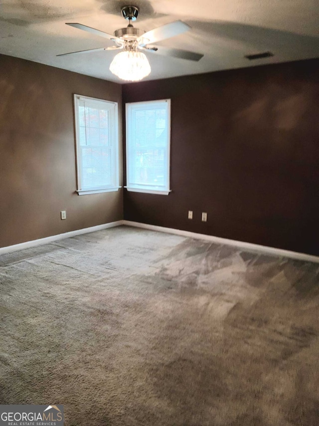 carpeted spare room with ceiling fan