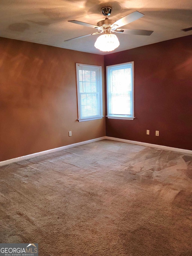 carpeted spare room with ceiling fan