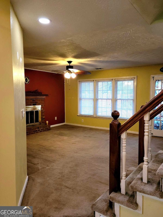 living room with carpet flooring, a brick fireplace, plenty of natural light, and ceiling fan