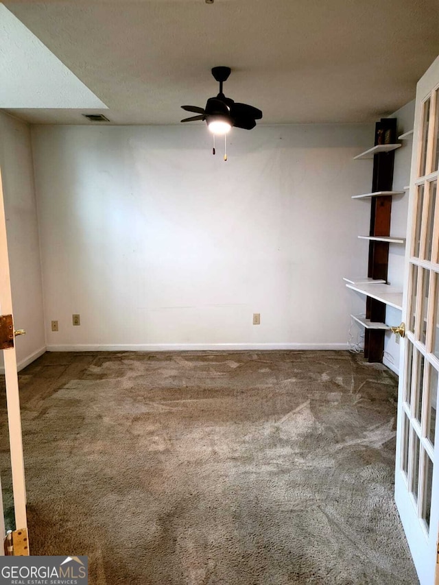 empty room featuring carpet flooring, ceiling fan, and a textured ceiling